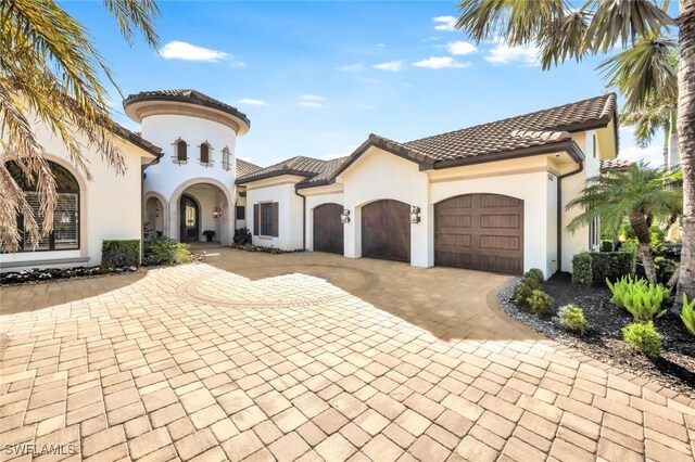 mediterranean / spanish-style house with a garage