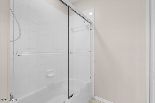 bathroom with combined bath / shower with glass door