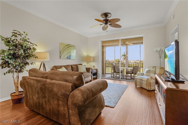 living room featuring ceiling fan, wood-type flooring, and ornamental molding