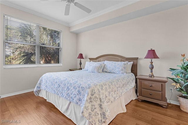 bedroom featuring hardwood / wood-style flooring, ceiling fan, ornamental molding, and multiple windows