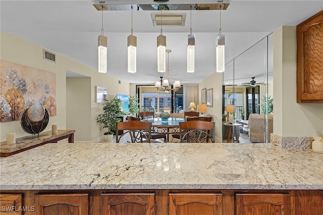 kitchen with ceiling fan with notable chandelier and hanging light fixtures