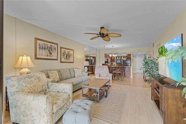 living room featuring ceiling fan with notable chandelier