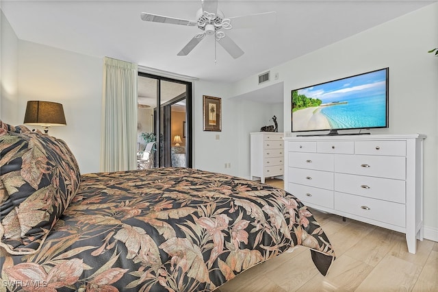 bedroom featuring access to outside, light wood-type flooring, expansive windows, and ceiling fan