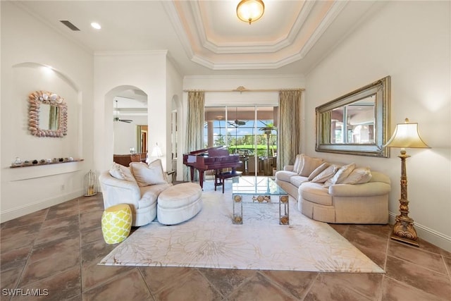 living room with ceiling fan, crown molding, and a tray ceiling