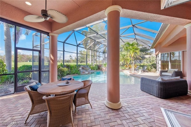 view of patio / terrace with ceiling fan, glass enclosure, and pool water feature