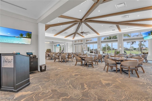 dining space with ceiling fan, carpet, a towering ceiling, and beamed ceiling