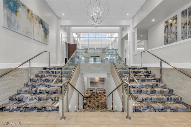 stairs with a notable chandelier