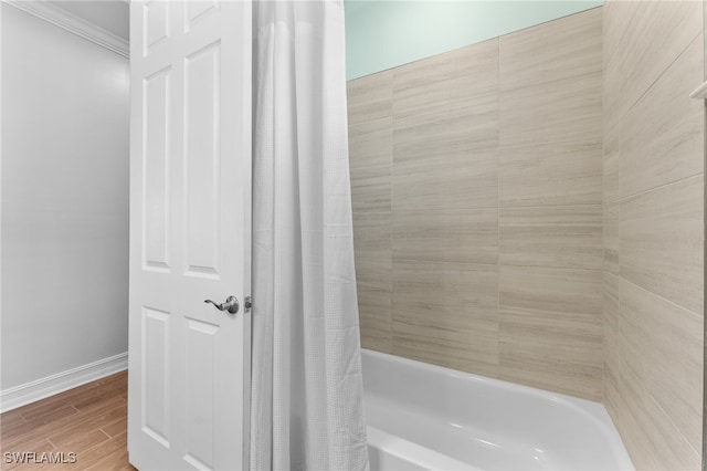 bathroom featuring crown molding and shower / bathtub combination with curtain