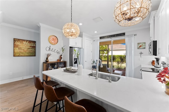 kitchen featuring sink, an inviting chandelier, stainless steel appliances, decorative light fixtures, and kitchen peninsula