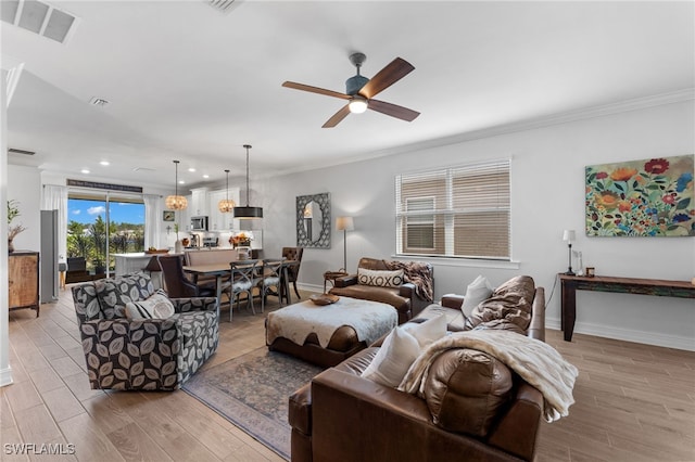 living room featuring crown molding, ceiling fan, and light wood-type flooring