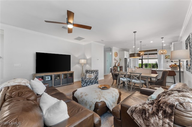 living room featuring ceiling fan, ornamental molding, and light hardwood / wood-style floors