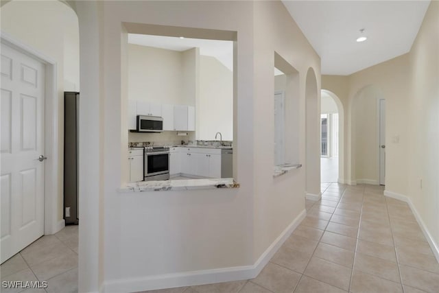 corridor featuring sink and light tile patterned floors