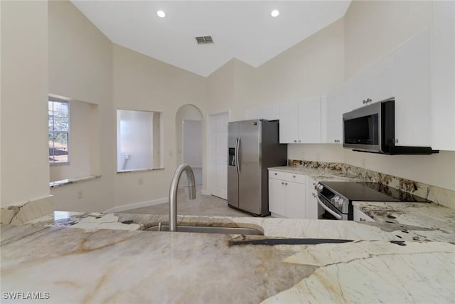 kitchen featuring white cabinetry, high vaulted ceiling, appliances with stainless steel finishes, and sink