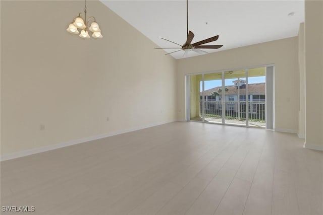 spare room with ceiling fan with notable chandelier, high vaulted ceiling, and light hardwood / wood-style flooring