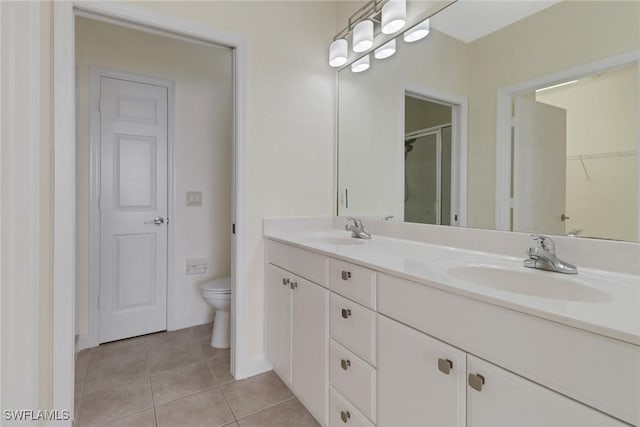 bathroom featuring vanity, tile patterned floors, toilet, and walk in shower