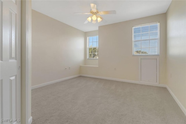 carpeted spare room with ceiling fan