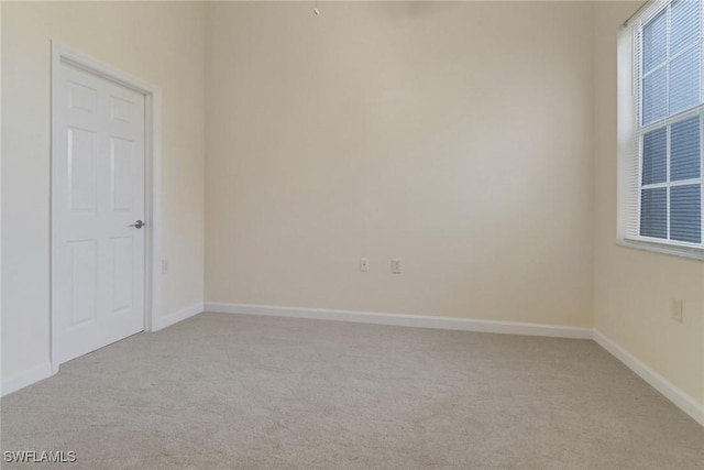 unfurnished room featuring light carpet