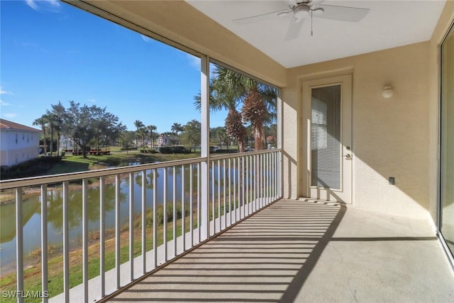 balcony featuring a water view and ceiling fan