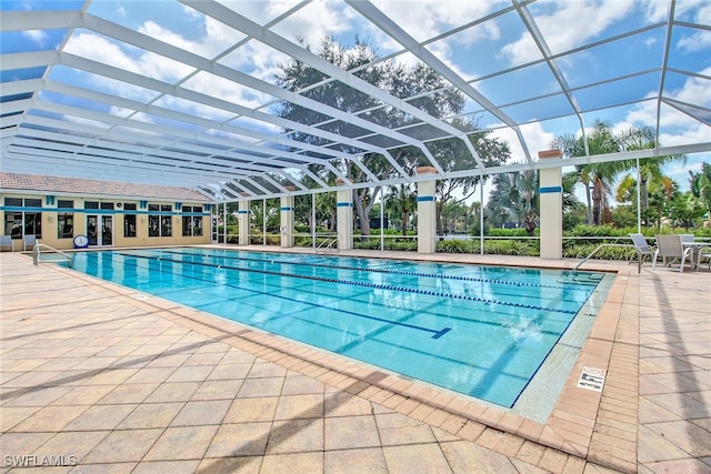 view of pool with a patio and glass enclosure