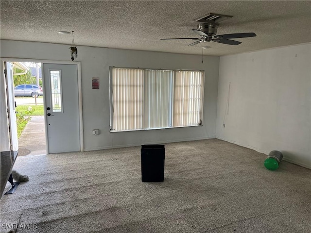 interior space with ceiling fan and a textured ceiling