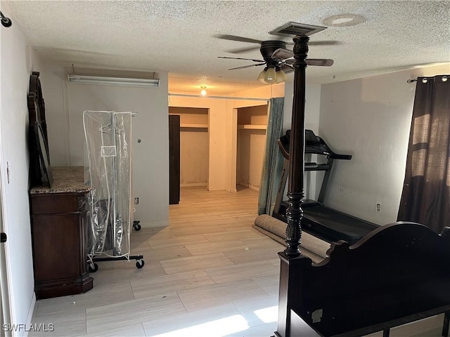 workout room featuring a textured ceiling and ceiling fan