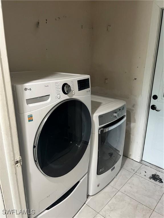 washroom featuring light tile patterned floors and washing machine and clothes dryer