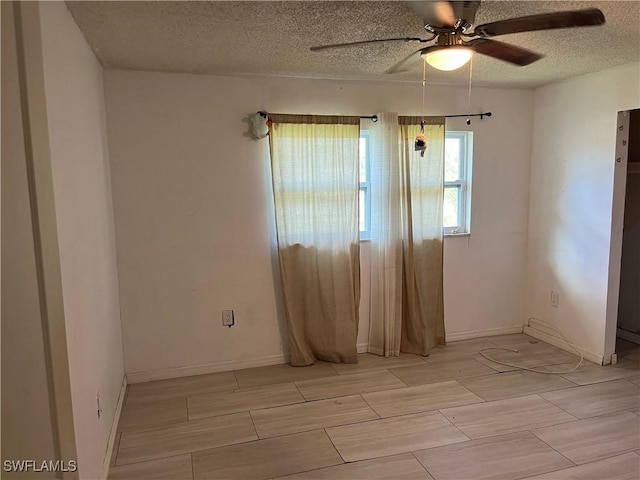 empty room with a textured ceiling and ceiling fan