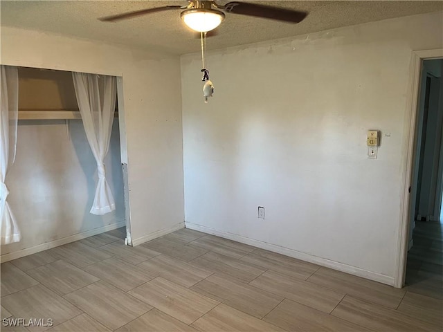 unfurnished room featuring ceiling fan and a textured ceiling