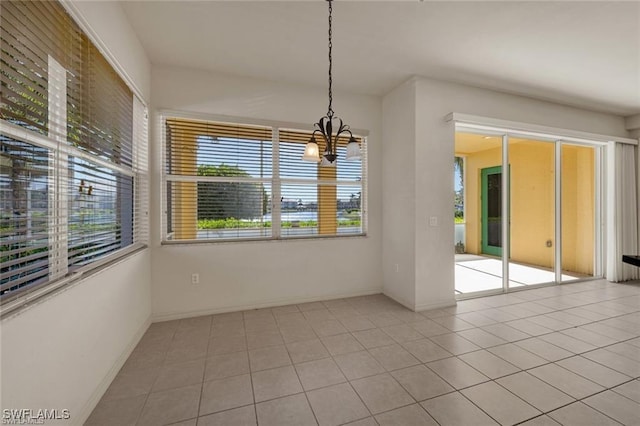 unfurnished dining area featuring light tile patterned floors and an inviting chandelier