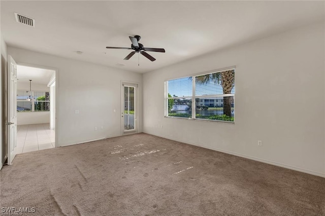 unfurnished room with light carpet and ceiling fan with notable chandelier