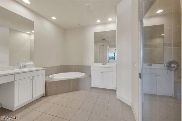 bathroom with tile patterned flooring, vanity, and plus walk in shower