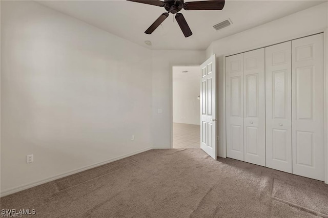 unfurnished bedroom with carpet floors, a closet, and ceiling fan