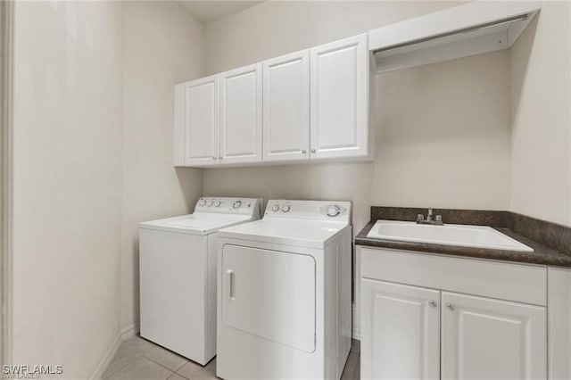 washroom with washer and dryer, cabinets, light tile patterned floors, and sink