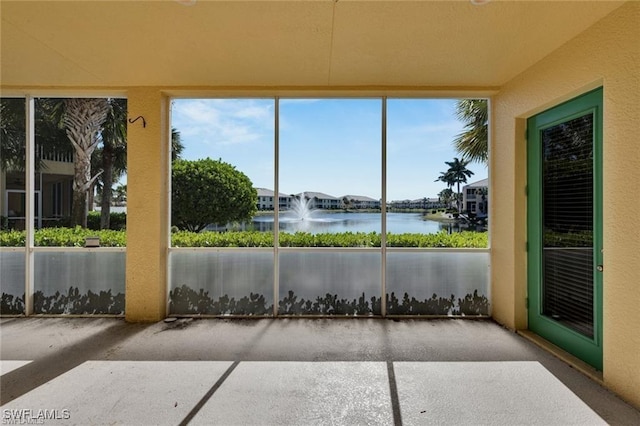 unfurnished sunroom with a water view