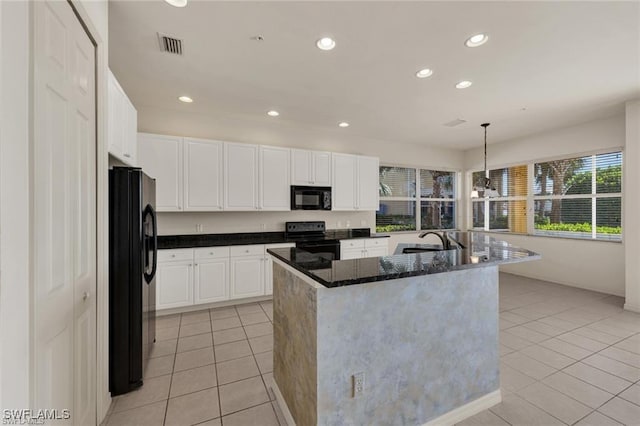 kitchen featuring a kitchen island with sink, black appliances, sink, decorative light fixtures, and white cabinetry