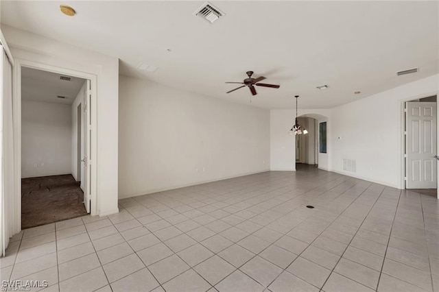 unfurnished room featuring light tile patterned floors and ceiling fan with notable chandelier