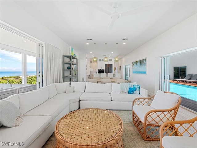 living room featuring a water view and ceiling fan