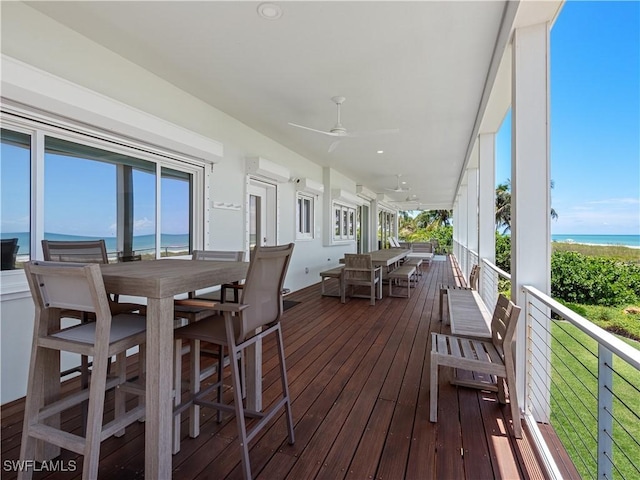 wooden deck featuring a lawn, ceiling fan, and a water view