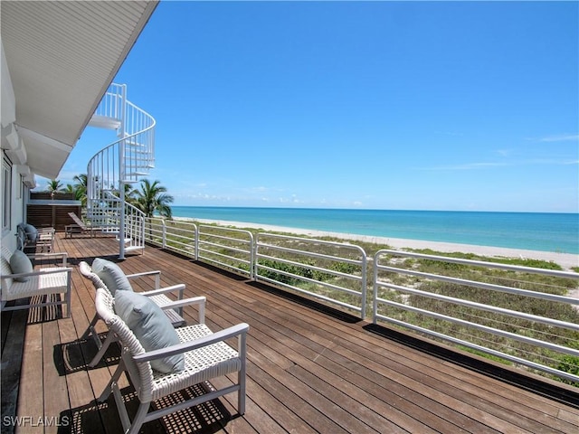 deck featuring a view of the beach and a water view