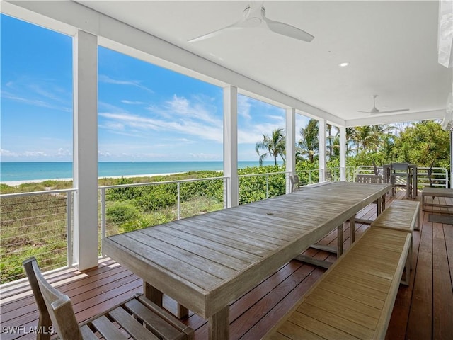 exterior space featuring a view of the beach, a water view, and ceiling fan