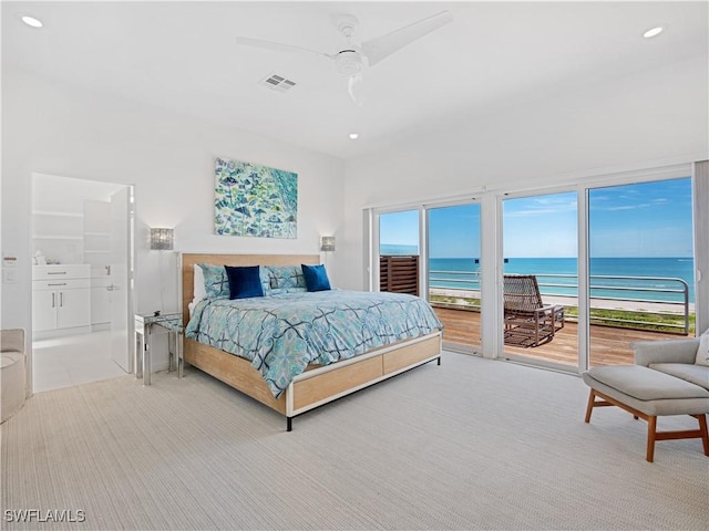 bedroom with access to exterior, ceiling fan, a beach view, ensuite bathroom, and a water view