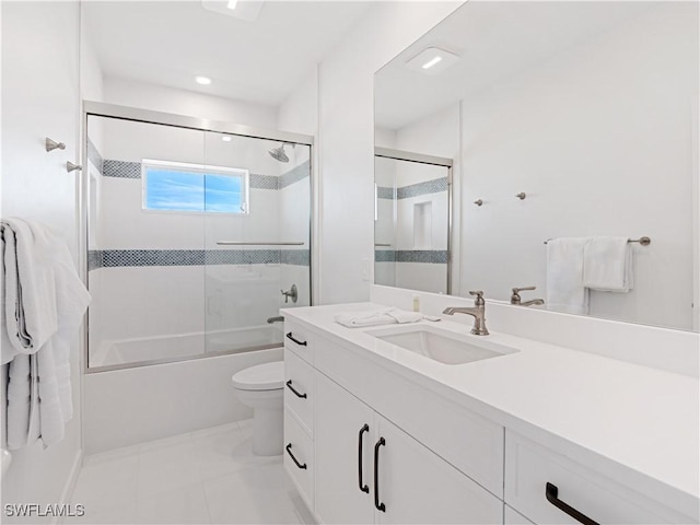 full bathroom featuring shower / bath combination with glass door, vanity, toilet, and tile patterned flooring