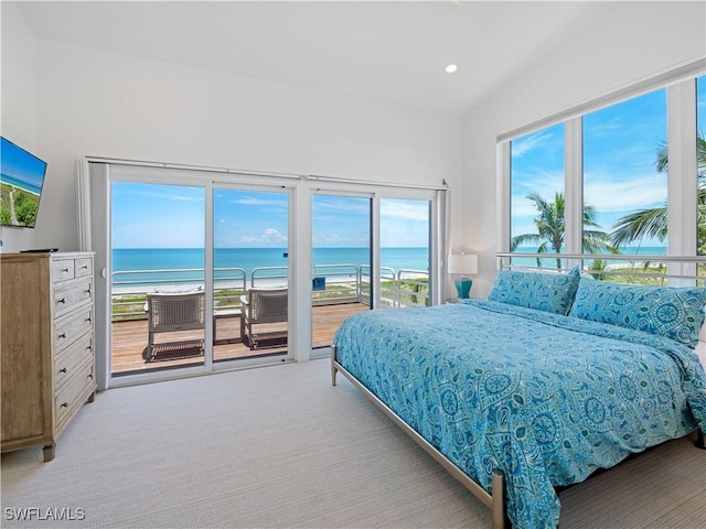 bedroom featuring a water view, light carpet, access to outside, and a view of the beach