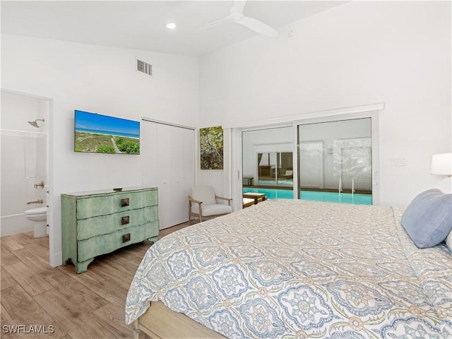 bedroom with ensuite bath, vaulted ceiling, ceiling fan, hardwood / wood-style flooring, and a closet