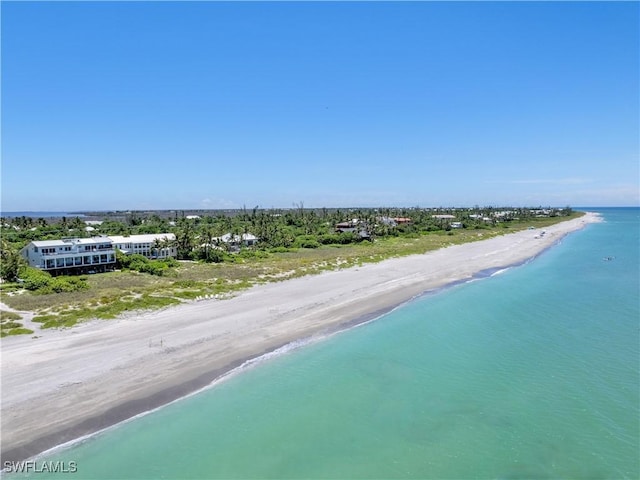 birds eye view of property with a water view and a beach view