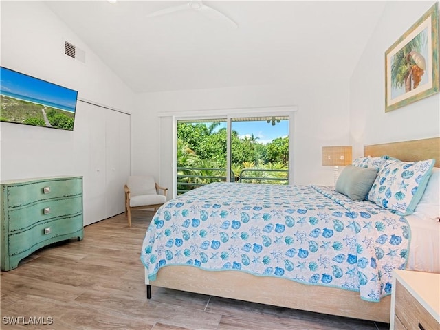 bedroom featuring access to outside, vaulted ceiling, light hardwood / wood-style flooring, ceiling fan, and a closet