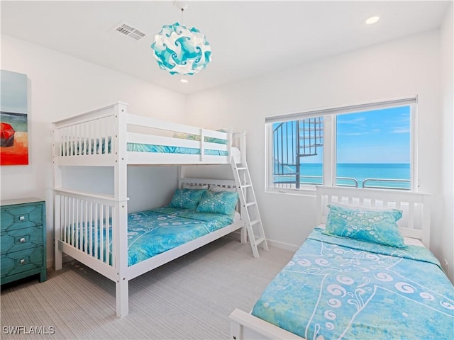 carpeted bedroom featuring a water view