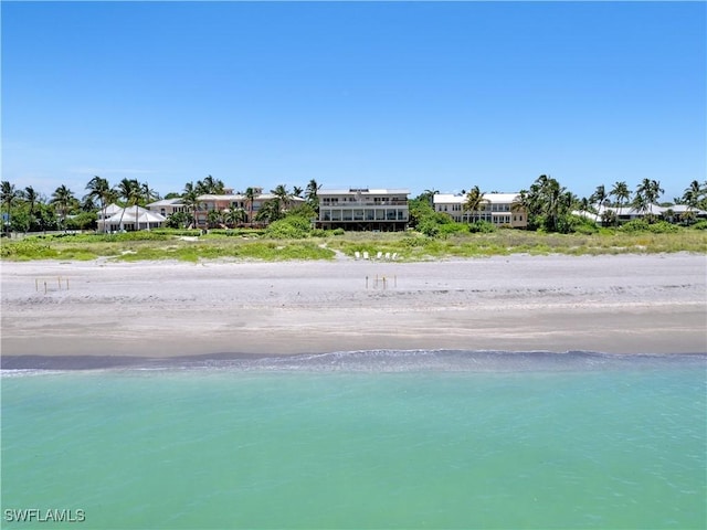 exterior space featuring a water view and a beach view