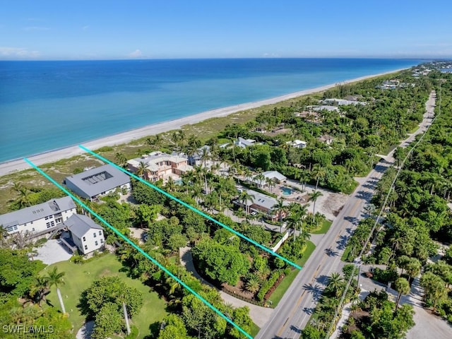 birds eye view of property with a water view and a beach view