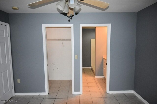 unfurnished bedroom featuring ceiling fan, light tile patterned flooring, and a closet